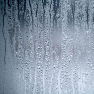 Close-up of bathroom mirror covered in condensation after a hot shower, illustrating indoor humidity.
